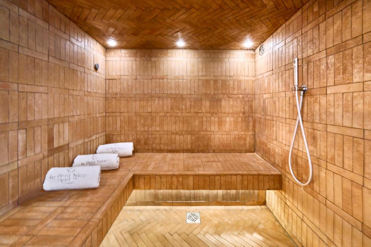 - une baignoire en bois avec douche et 2 serviettes dans l'établissement Le Petit Nice - Passedat, à Marseille