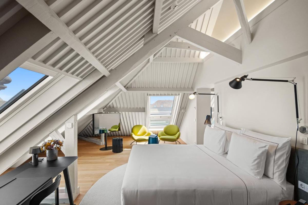 um quarto com uma cama branca e cadeiras amarelas em The Lince Santa Clara em Vila do Conde um quarto com uma cama branca e cadeiras amarelas em The Lince Santa Clara em Vila do Conde