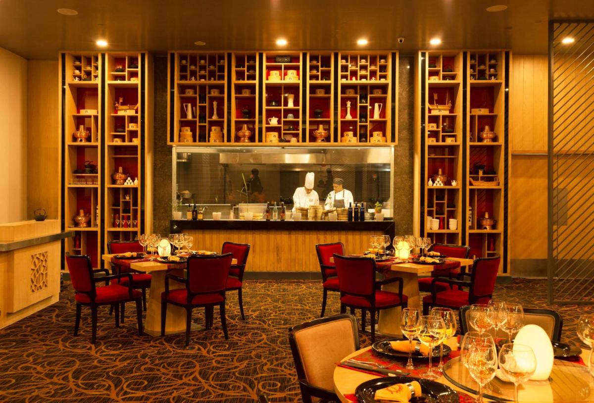 a restaurant with tables and chairs and a bar at Radisson Blu Bengaluru Outer Ring Road in Bengaluru