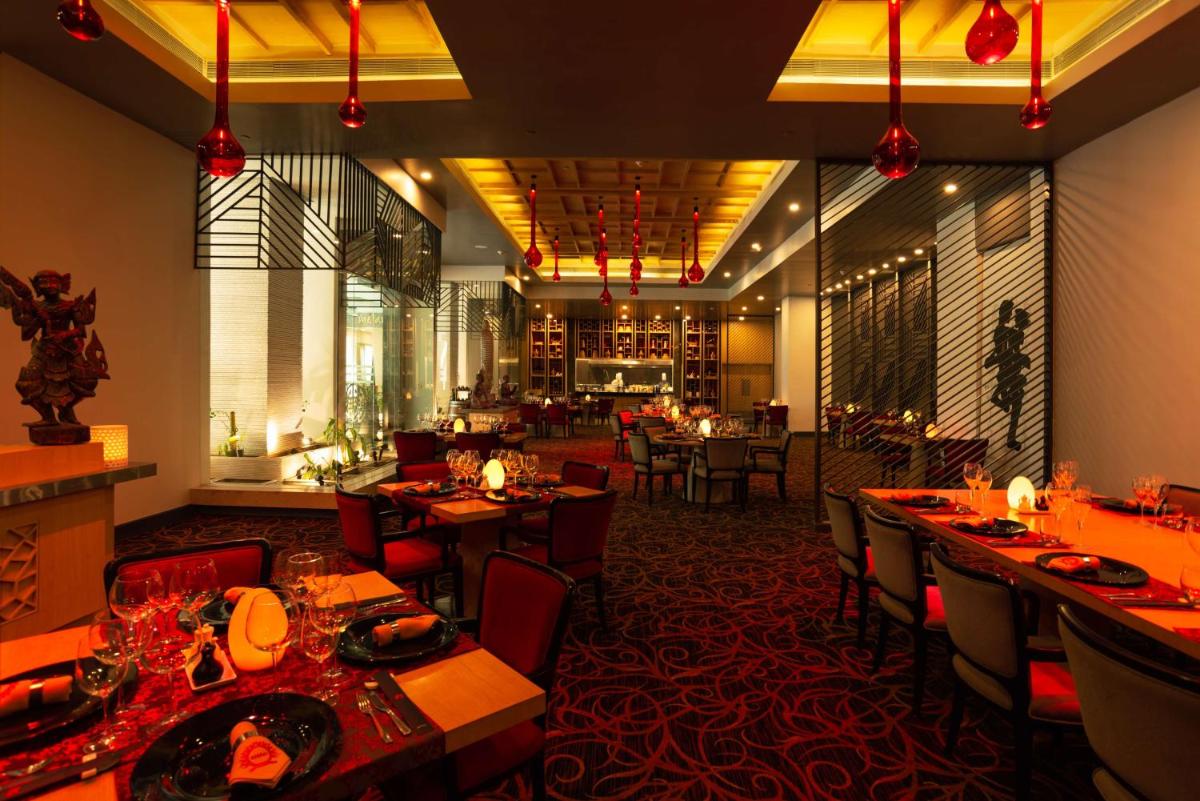 a dining room with tables and chairs in a restaurant at Radisson Blu Bengaluru Outer Ring Road in Bengaluru
