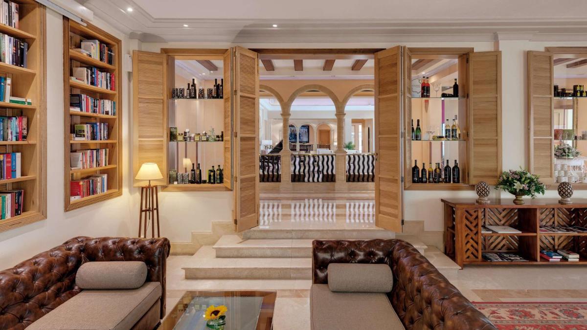 una sala de estar con sofá y estanterías de libros en Steigenberger Hotel and Resort Camp de Mar, en Camp de Mar