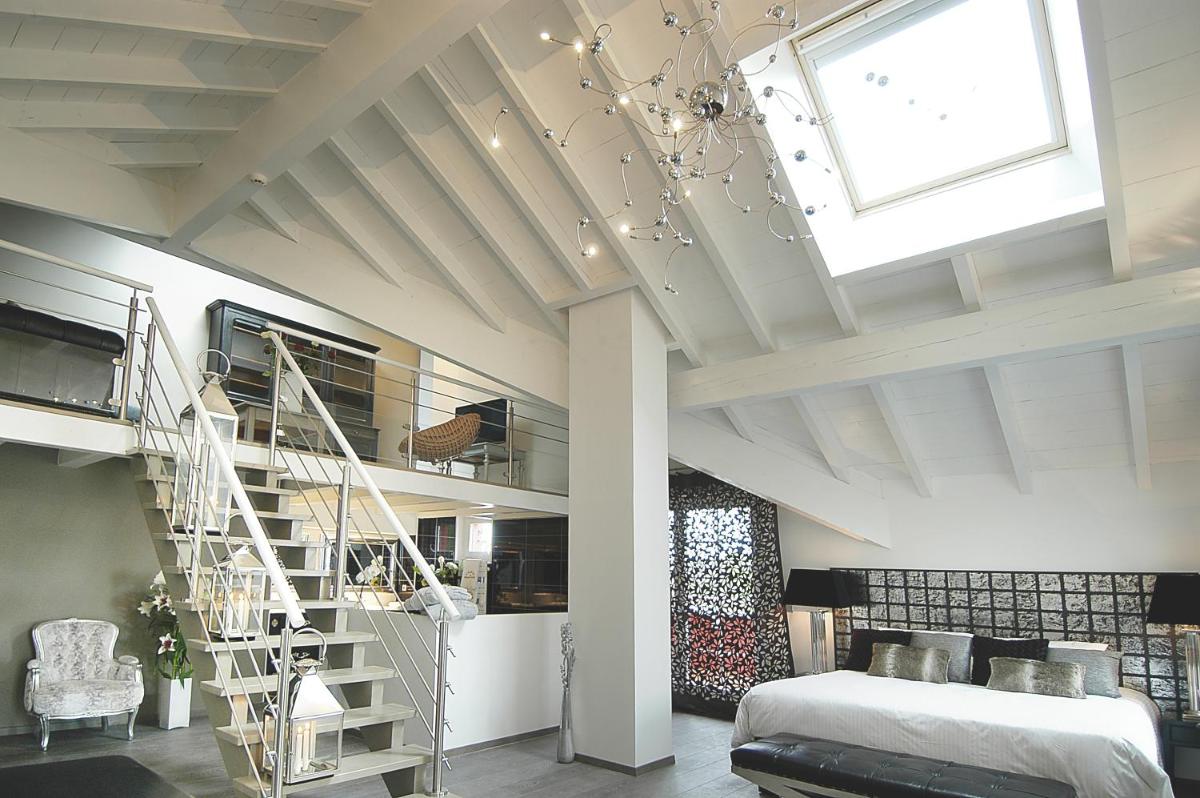 une chambre avec un lit et un escalier en colimaçon dans l'établissement Auberge De Maison Rouge, à Vétraz-Monthoux