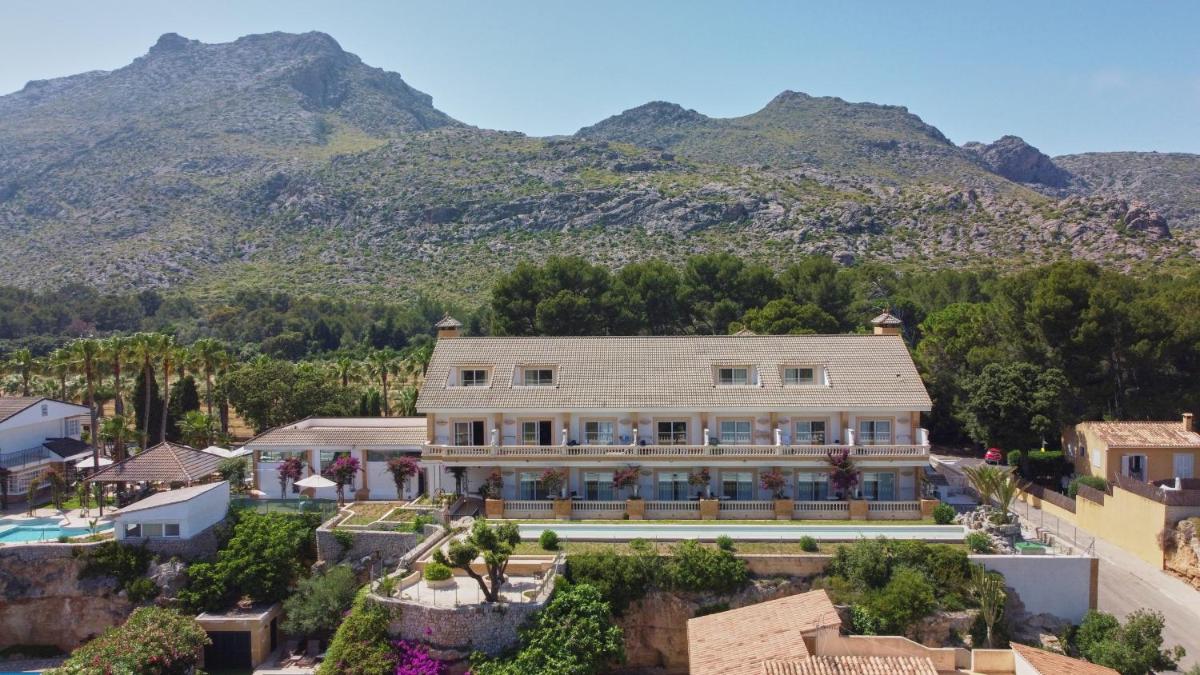 Una vista aérea de una casa con montañas al fondo. en La Moraleja The Quiet Hotel - Adults Only, en Cala de Sant Vicent