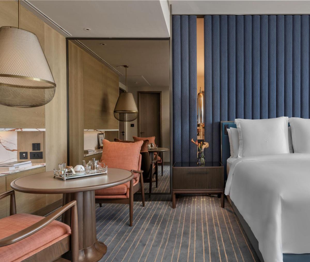 a hotel room with a bed and a table at Four Seasons Hotel Mumbai in Mumbai