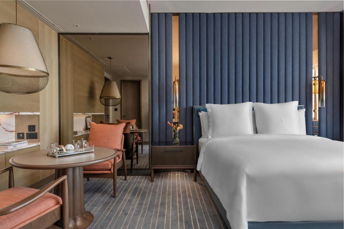 a hotel room with a large bed and a table at Four Seasons Hotel Mumbai in Mumbai