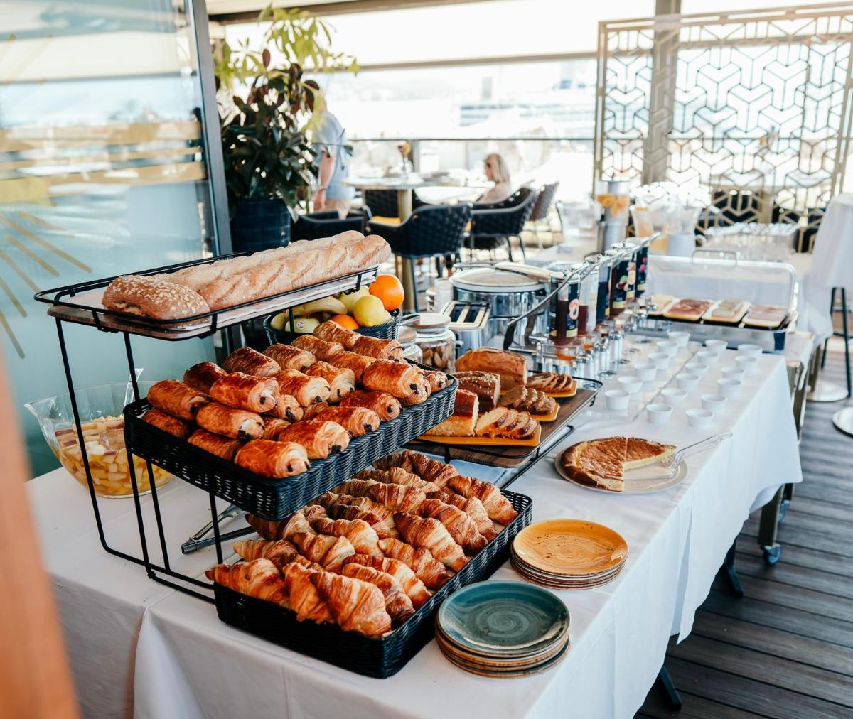 - une longue table avec du pain et des viennoiseries dans l'établissement Hôtel Fesch & Spa, à Ajaccio