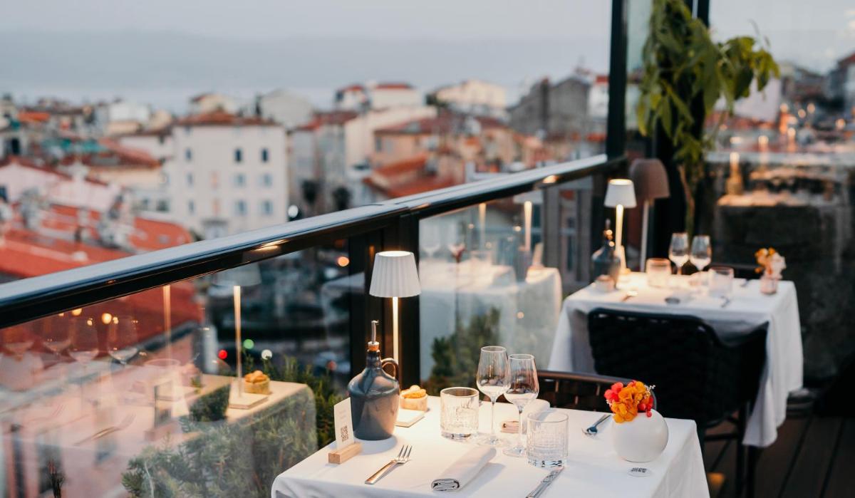 - un ensemble de tables avec des verres à vin sur un balcon dans l'établissement Hôtel Fesch & Spa, à Ajaccio