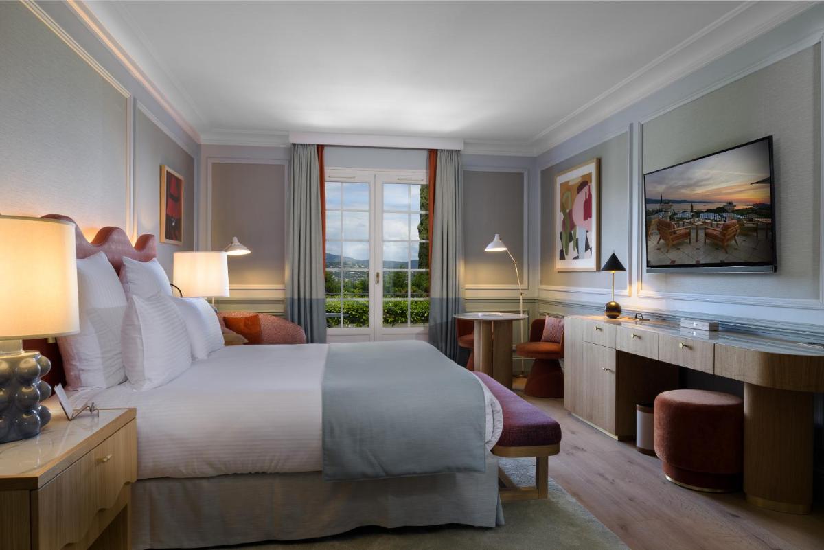une chambre avec un grand lit blanc et une fenêtre dans l'établissement Althoff Hotel Villa Belrose, à Saint-Tropez