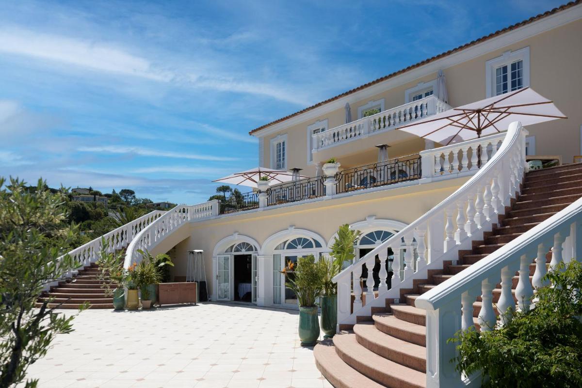 Un grand bâtiment blanc avec des escaliers et un balcon est disponible. dans l'établissement Althoff Hotel Villa Belrose, à Saint-Tropez