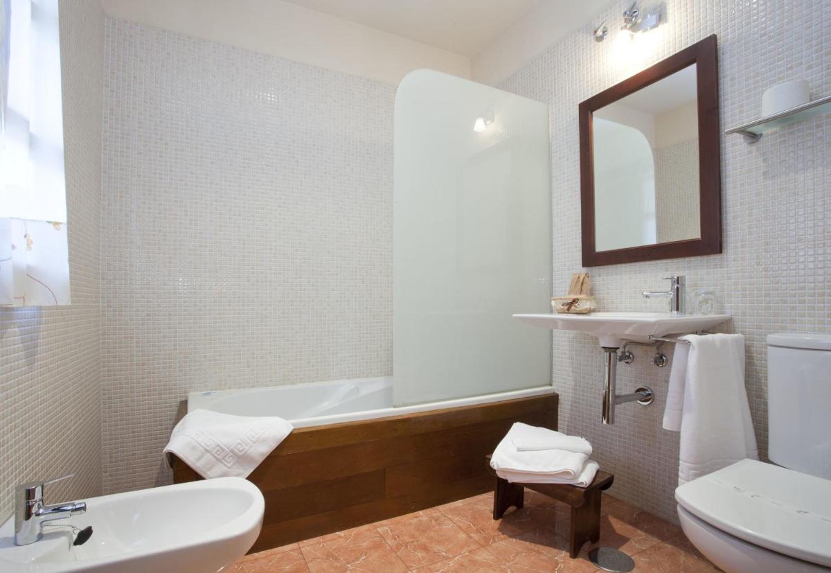 Un baño con bañera, lavabo e inodoro. en Hotel Rural El Fundil, en El Pino 32 fotos más