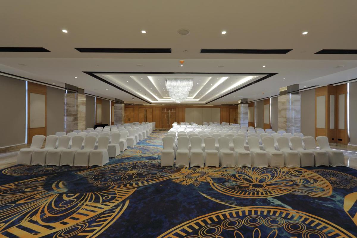 a room with rows of white chairs on a carpet at Hilton Garden Inn Pune Hinjawadi in Pune