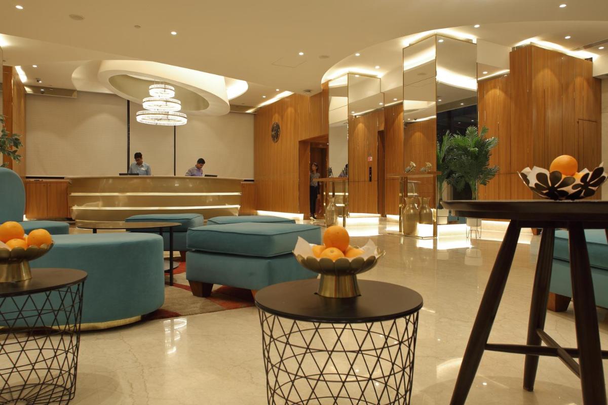 a lobby with a waiting area with oranges on tables at Hilton Garden Inn Pune Hinjawadi in Pune