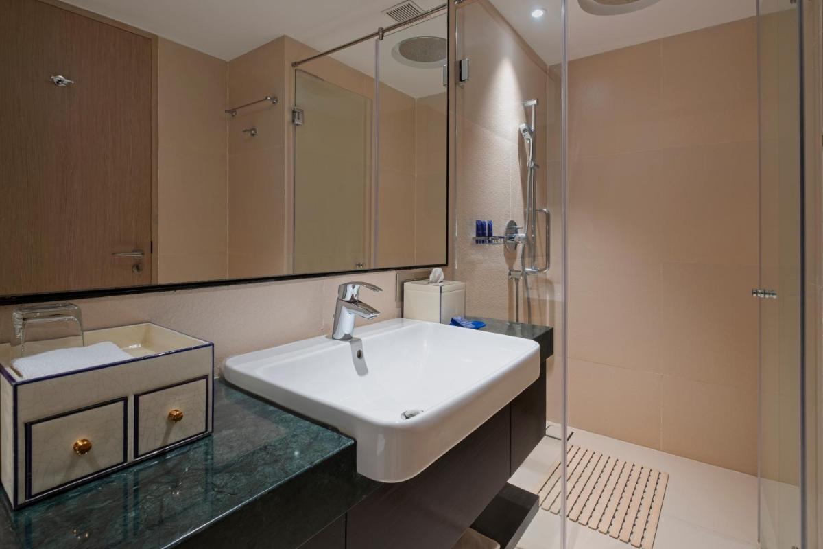 a bathroom with a sink and a shower at Vivanta Goa, Miramar in Panaji a bathroom with a sink and a shower at Vivanta Goa, Miramar in Panaji