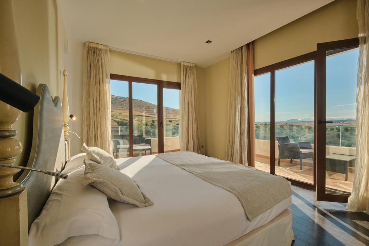 Un dormitorio con una cama grande y una ventana grande. en Hotel Spa Villa Nazules, en Chueca