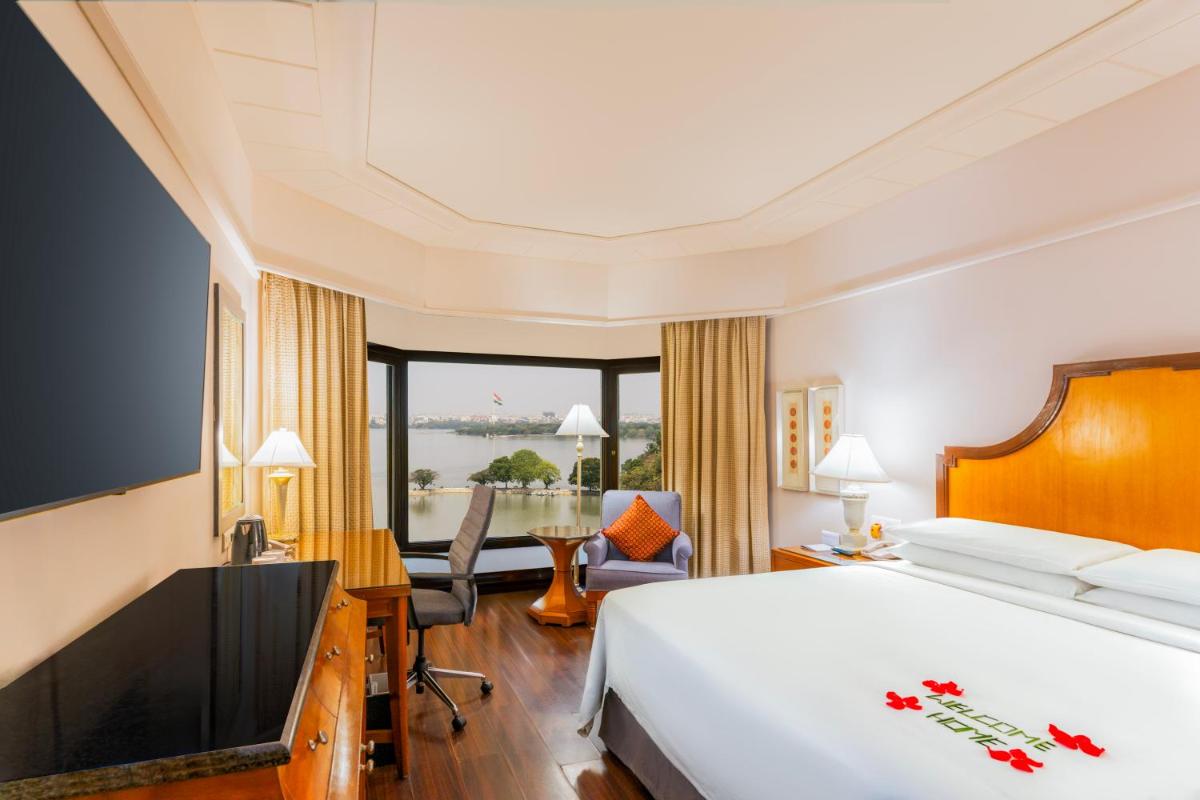 a hotel room with a large bed and a desk at Hyderabad Marriott Hotel & Convention Centre in Hyderabad