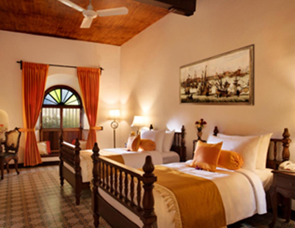 a bedroom with two beds and a ceiling at Forte Kochi in Cochin