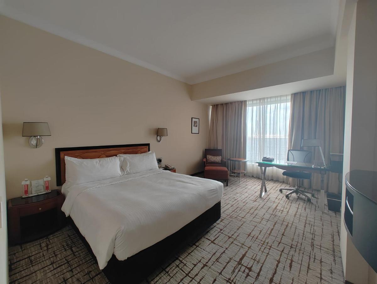 a hotel room with a bed and a desk at Hotel Marine Plaza in Mumbai