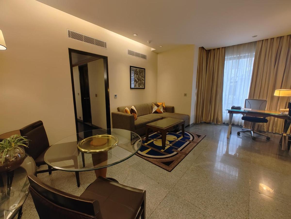 a living room with a glass table and a couch at Hotel Marine Plaza in Mumbai