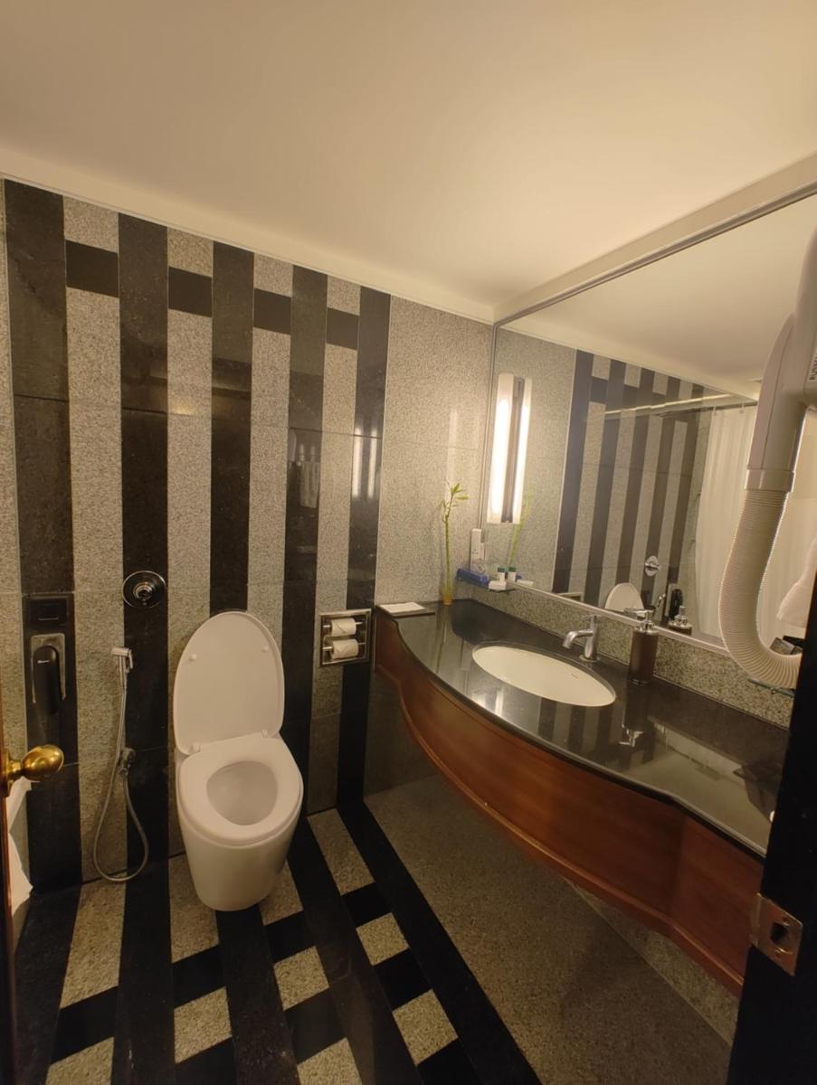 a bathroom with a toilet and a sink at Hotel Marine Plaza in Mumbai