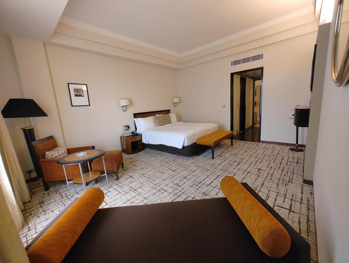 a hotel room with a bed and a couch at Hotel Marine Plaza in Mumbai