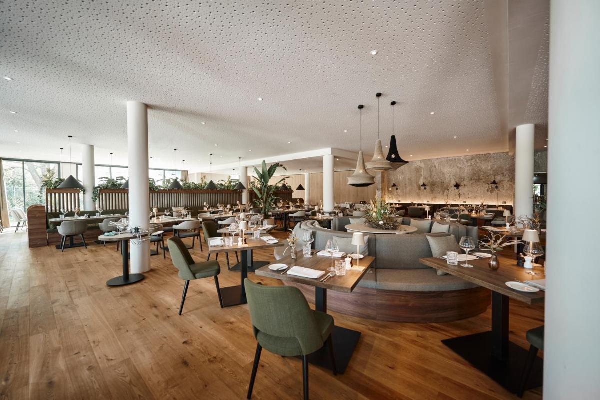 ein Restaurant mit Tischen und Stühlen in einem Raum in der Unterkunft Nouri in Bad Krozingen
