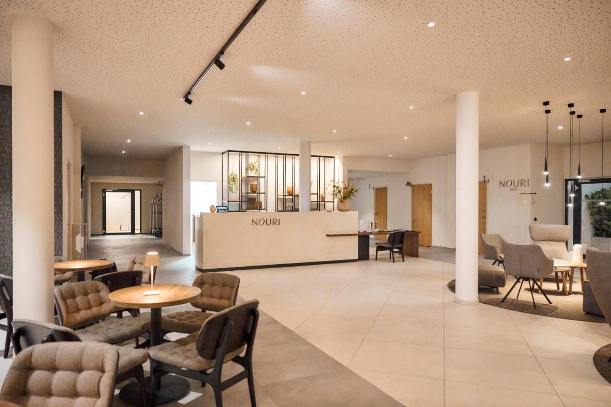 eine Lobby mit einem Wartebereich mit Stühlen und Tischen in der Unterkunft Nouri in Bad Krozingen