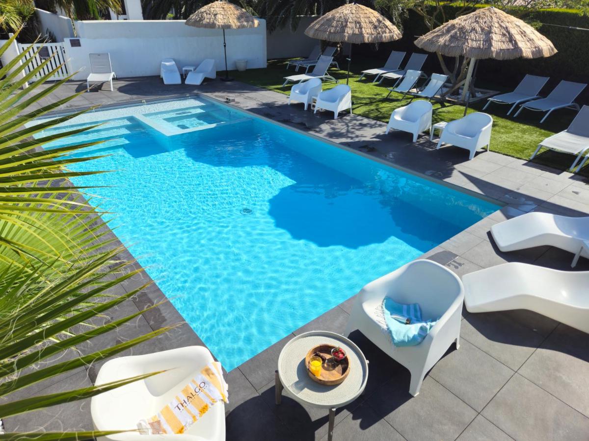 vue aérienne d'une piscine avec des chaises et une table dans l'établissement Hôtel Ancre Marine & Spa Thalgo ***, à Noirmoutier-en-l'lle