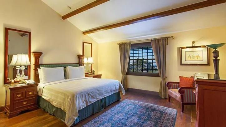 a bedroom with a large bed and a window at The Oberoi Cecil in Shimla