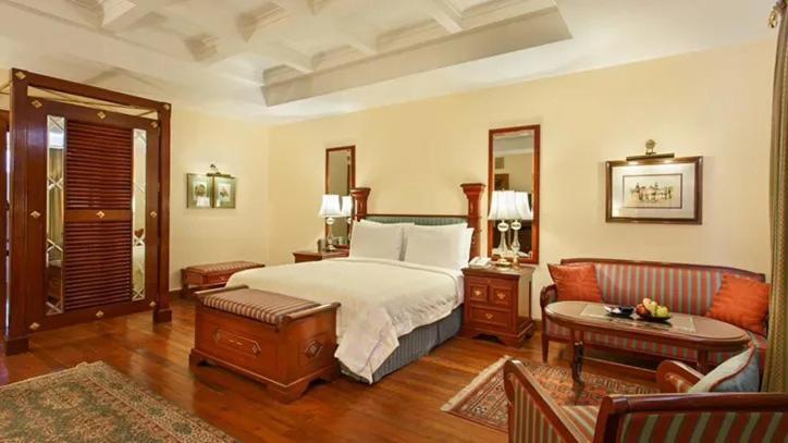 a bedroom with a bed and a living room at The Oberoi Cecil in Shimla