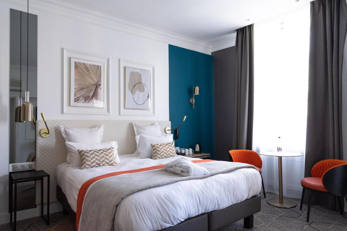 une chambre avec un grand lit et des murs bleus dans l'établissement Oceania Hôtel d'Anjou Angers, à Angers