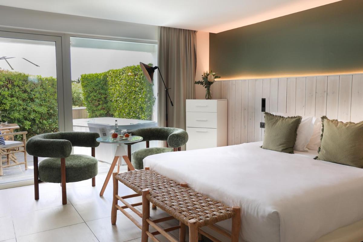 une chambre avec un lit, une table et des chaises dans l'établissement Hôtel & Spa Le Grand Large, à Dolus-d'Oléron