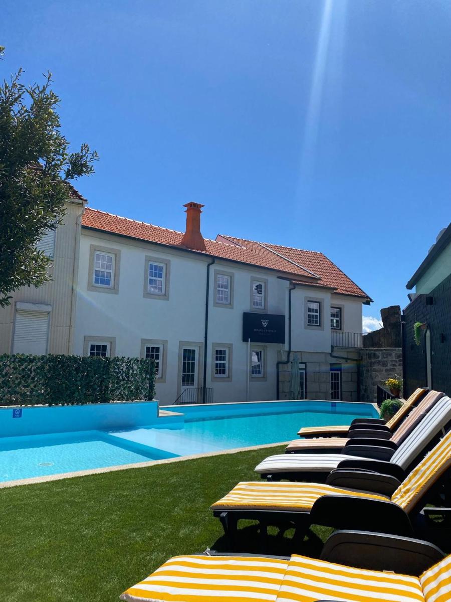 uma fileira de espreguiçadeiras ao lado de uma piscina em Douro Castelo Signature Hotel & Spa em Lamego