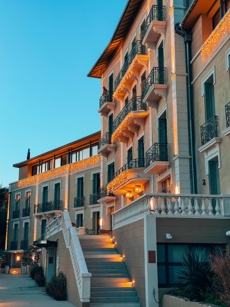 Un grand bâtiment est accessible par des escaliers. dans l'établissement Eden Rose Grand Hotel BW Premier Collection, à Bormes-les-Mimosas