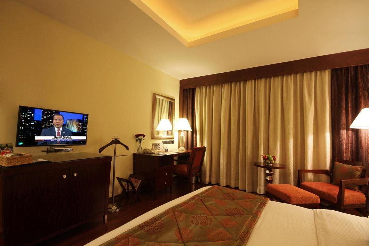 a hotel room with a bed and a flat screen tv at Fortune Select JP Cosmos, Bengaluru - Member ITC Hotels' Group in Bengaluru