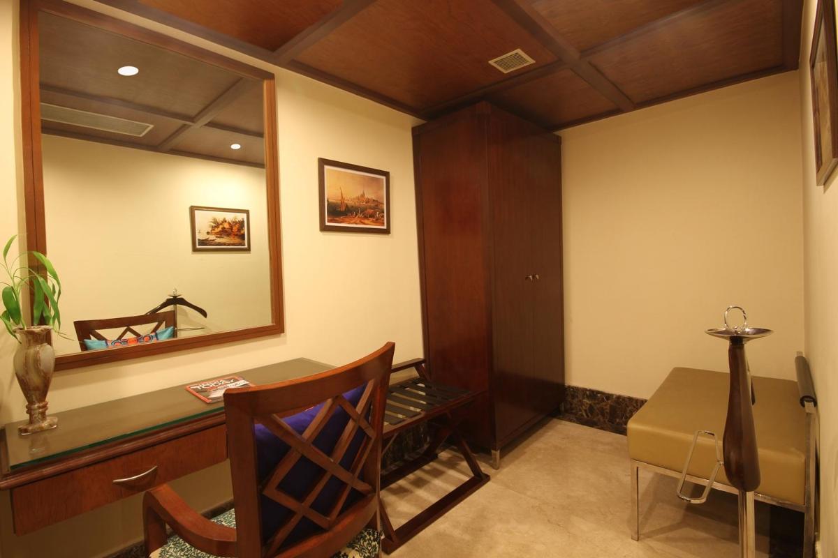 a room with a desk and a mirror at Fortune Select JP Cosmos, Bengaluru - Member ITC Hotels' Group in Bengaluru