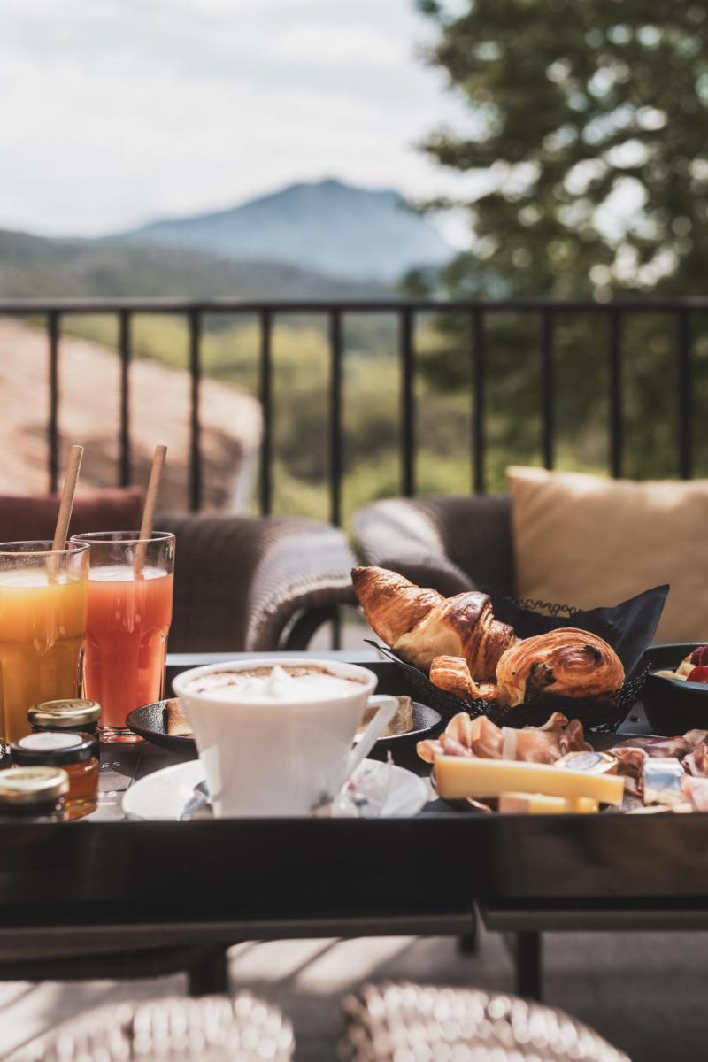 une table avec de la nourriture et des boissons sur une terrasse dans l'établissement Les Lodges Sainte-Victoire Hotel & Spa, à Aix-en-Provence
