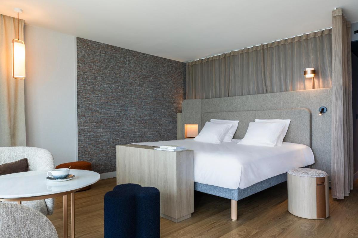 une chambre d'hôtel avec un lit et une table dans l'établissement Oceania Saint Malo, à Saint-Malo