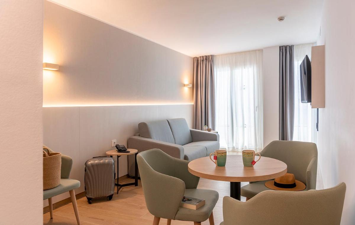 una sala de estar con una mesa y sillas en Aparthotel Costa Encantada, en Lloret de Mar