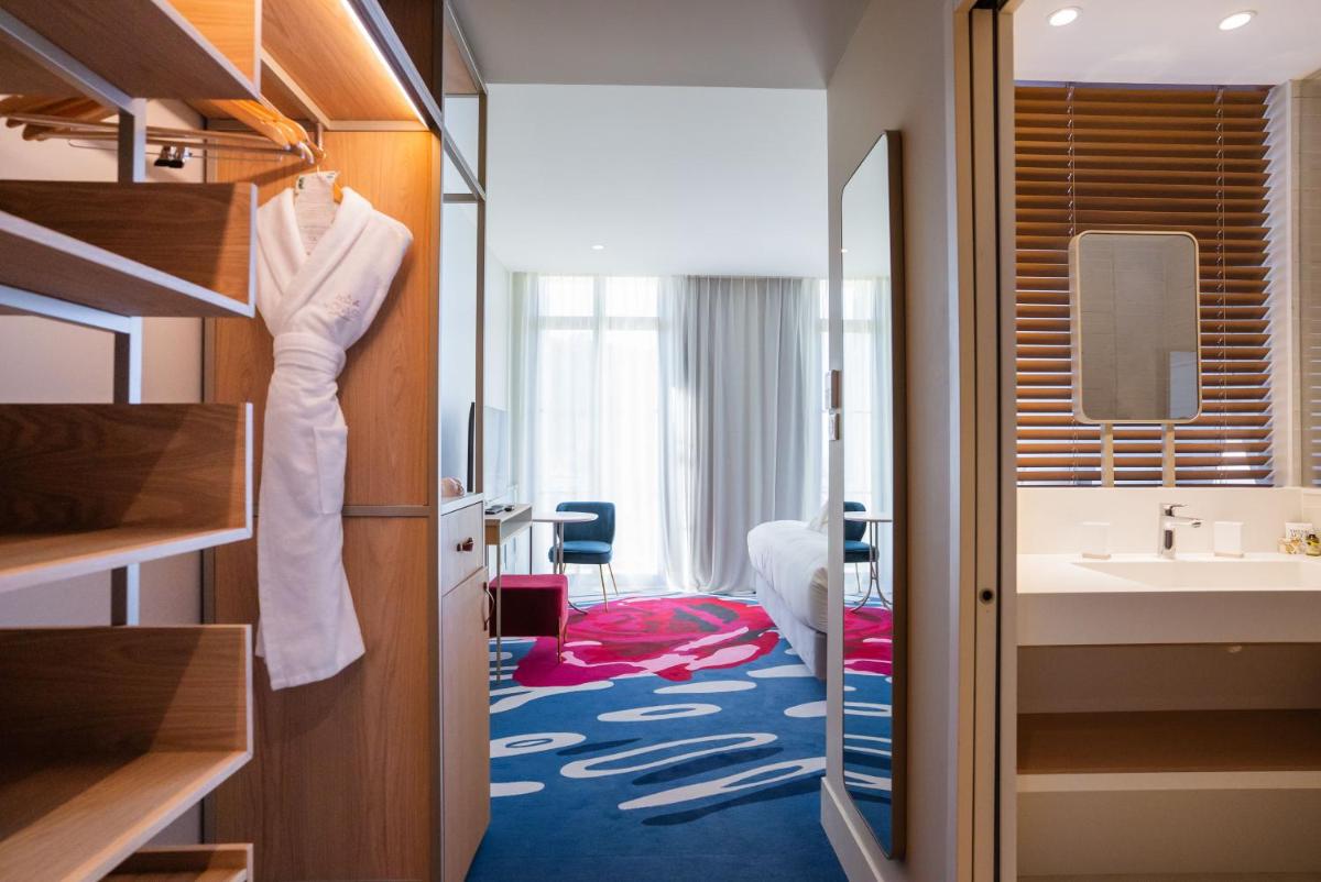 une chambre d'hôtel avec un lavabo et une chambre dans l'établissement Eden Rose Grand Hotel BW Premier Collection, à Bormes-les-Mimosas