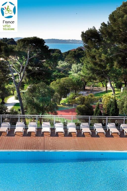 un groupe de chaises longues assises à côté d'une piscine dans l'établissement Hôtel Club la Font des Horts, à Hyères