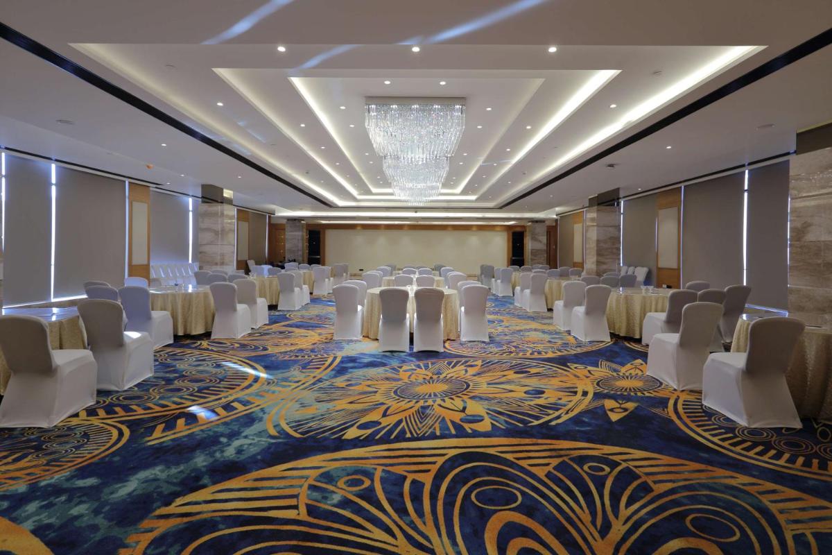 a conference room with chairs and tables and a chandelier at Hilton Garden Inn Pune Hinjawadi in Pune