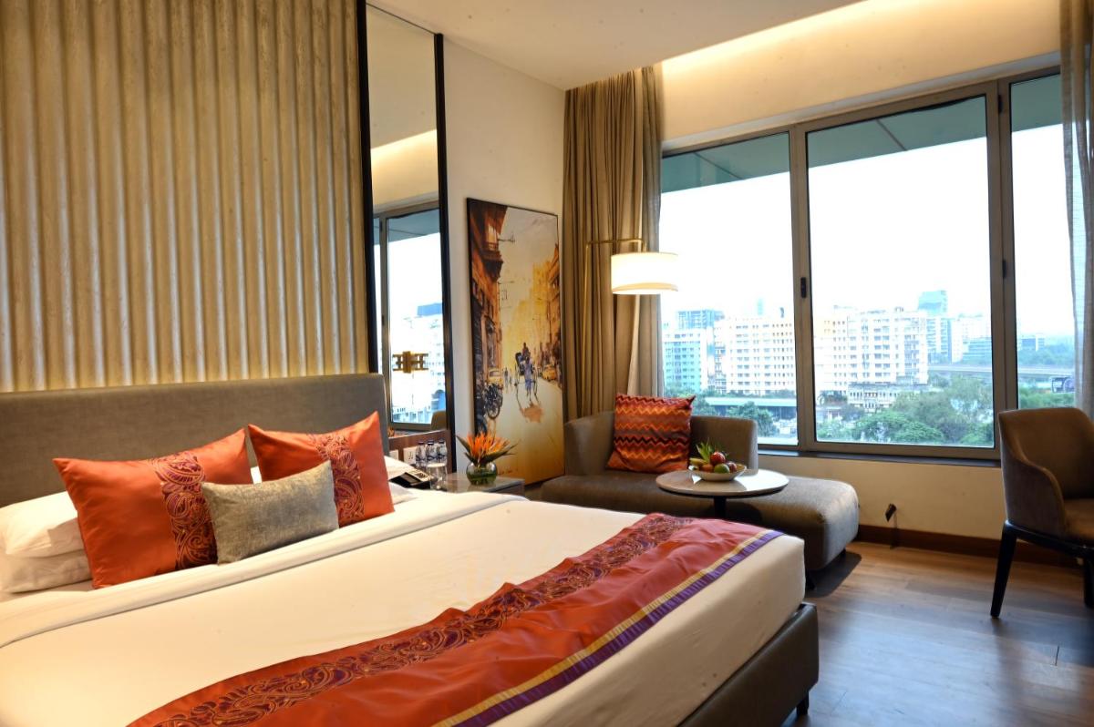 a hotel room with a bed and a large window at Vivanta Kolkata EM Bypass in Kolkata