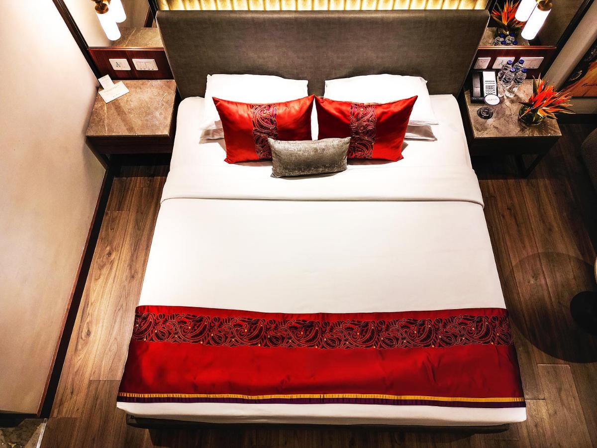 a bedroom with a large bed with red pillows at Vivanta Kolkata EM Bypass in Kolkata