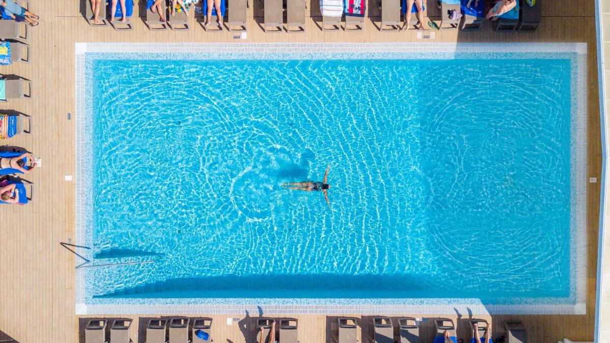uma pessoa nadando em uma grande piscina em Jupiter Algarve Hotel - Beach & Spa em Portimão