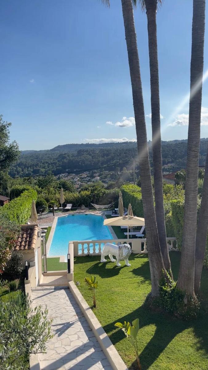 une villa avec piscine et palmiers dans l'établissement La Bastide Gourmande, à La Colle-sur-Loup