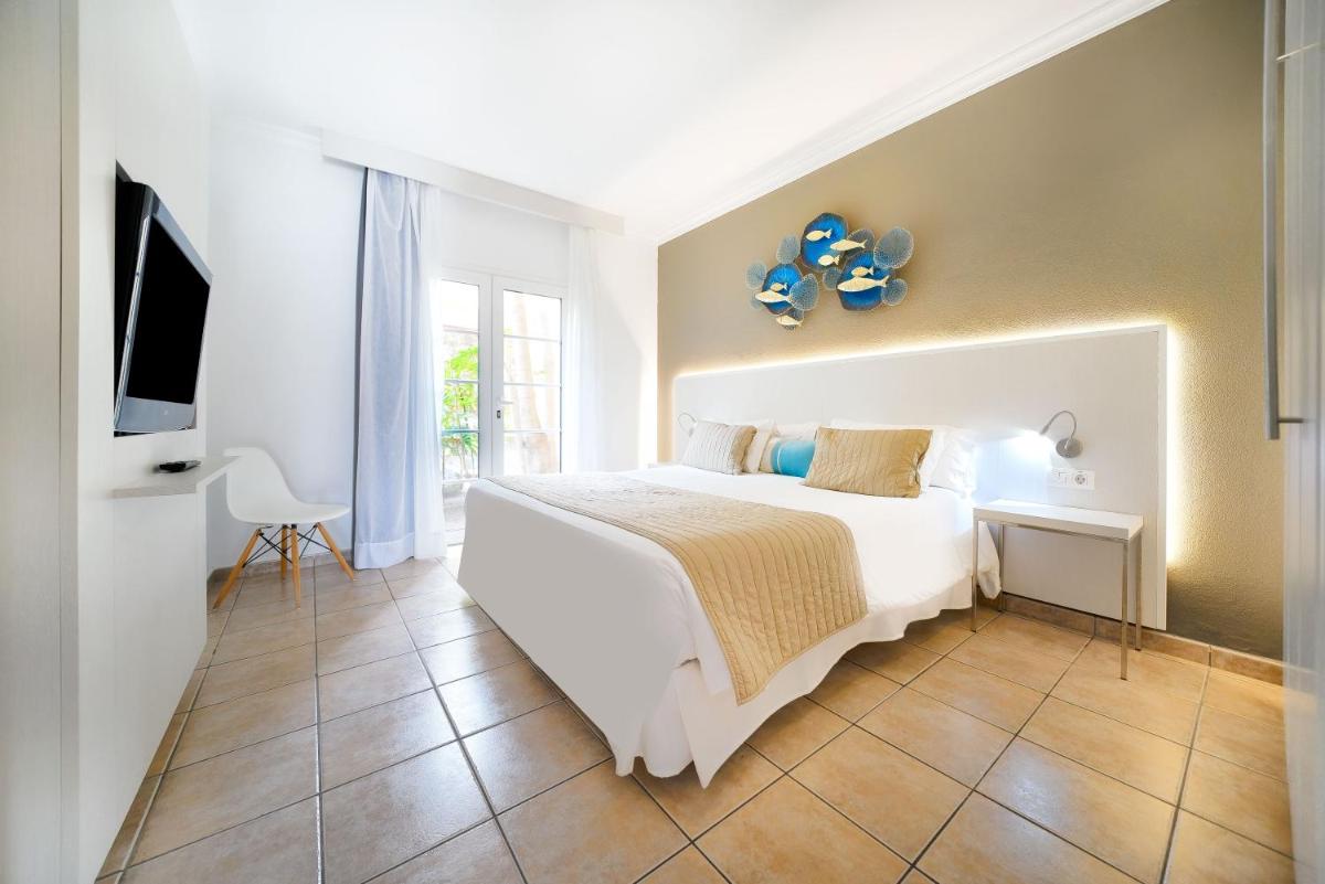 Un dormitorio con una gran cama blanca y un televisor. en Bull Vital Suites & Spa Boutique Hotel - Only Adults, en Playa del Inglés 32 fotos más
