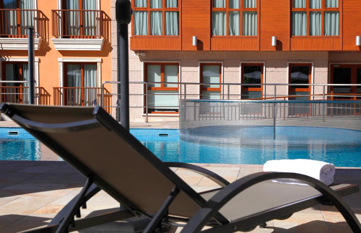 una silla sentada frente a una piscina en Apartahotel & Spa Jacetania, en Jaca
