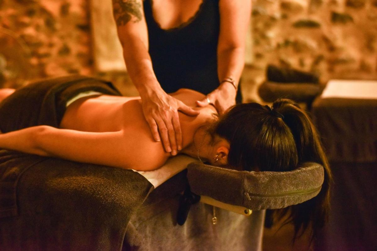 une femme recevant un massage d'un thérapeute dans l'établissement Hotel Logis - Chateau de Beauregard, à Saint-Girons