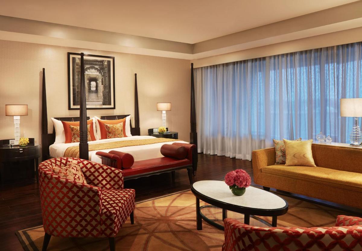 a hotel room with a bed and a couch at Taj Santacruz in Mumbai