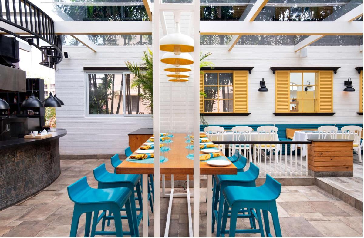 a dining room with a table and blue chairs at Radisson Blu Bengaluru Outer Ring Road in Bengaluru